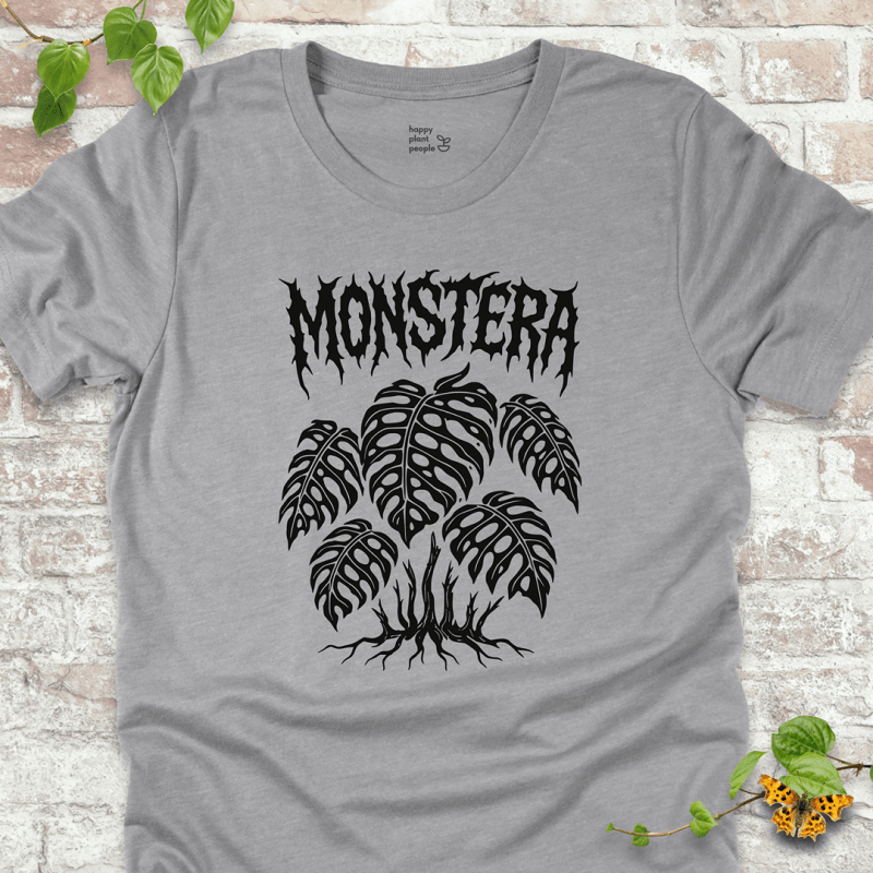 Athletic heather grey Monstera T-shirt showing twisted Monstera leaves and roots, styled for plant lovers.