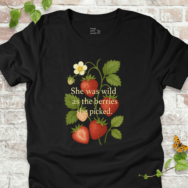 She Was Wild T-Shirt in Black, featuring strawberries, green leaves, and the quote 'She was wild as the berries she picked' on soft Bella+Canvas tee.