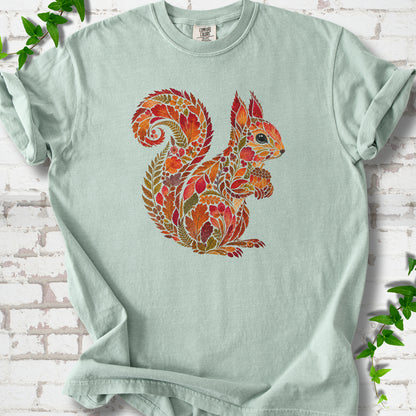 Moss Comfort Colors® T-shirt flat lay with an autumn squirrel graphic made from colorful leaves, ferns and flowers.