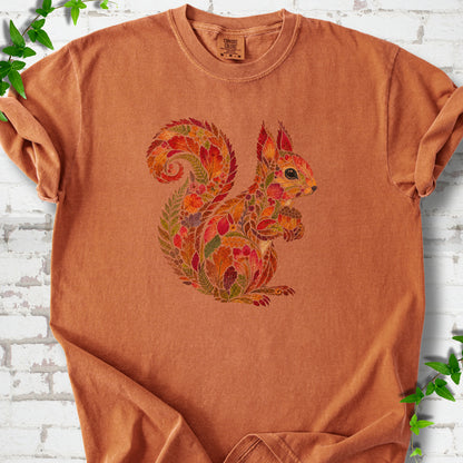Khaki Comfort Colors® T-shirt flat lay with an autumn squirrel graphic made from colorful leaves, ferns and flowers.