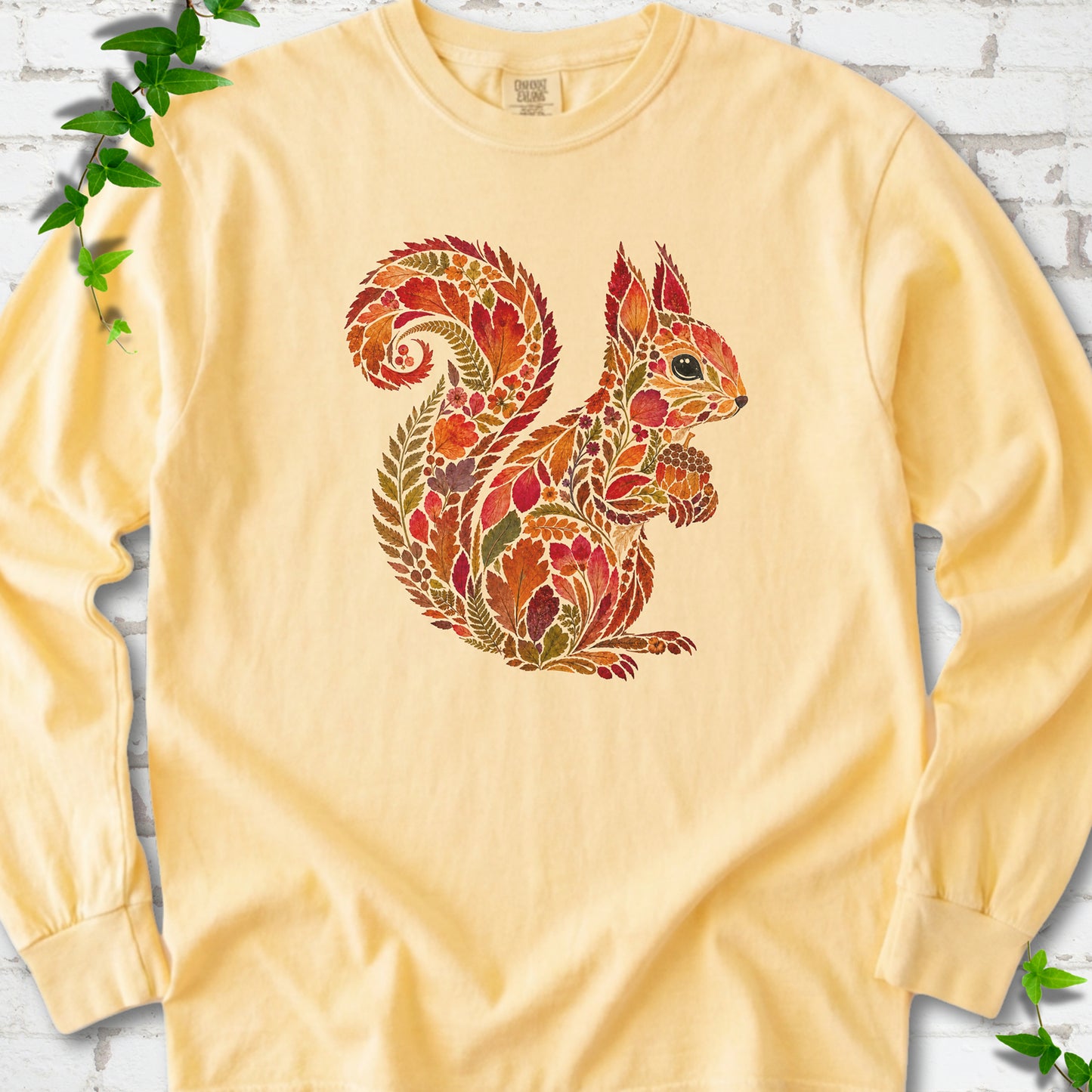 Yam Comfort Colors® long sleeve T-shirt flat lay with an autumn squirrel graphic made from colorful leaves, ferns and flowers.