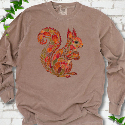 Pepper Comfort Colors® long sleeve T-shirt flat lay with an autumn squirrel graphic made from colorful leaves, ferns and flowers.