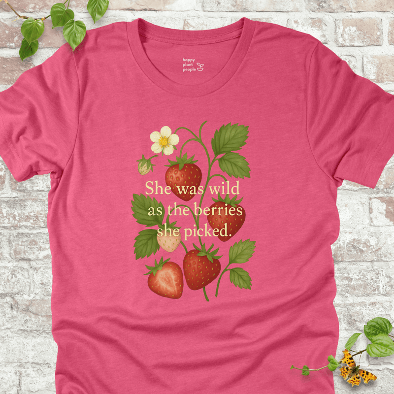 She Was Wild T-Shirt in Heather Raspberry, featuring strawberries, green leaves, and the quote 'She was wild as the berries she picked' on soft Bella+Canvas tee