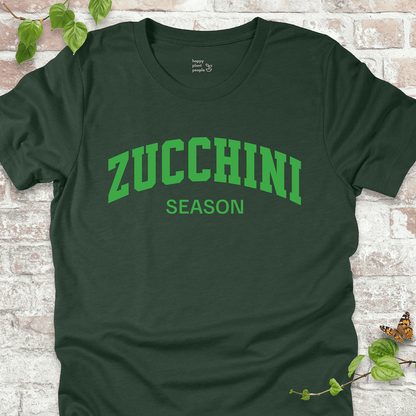 Zucchini Season T-Shirt in Heather Forest, featuring bold varsity-style cream text on soft Bella+Canvas tee.