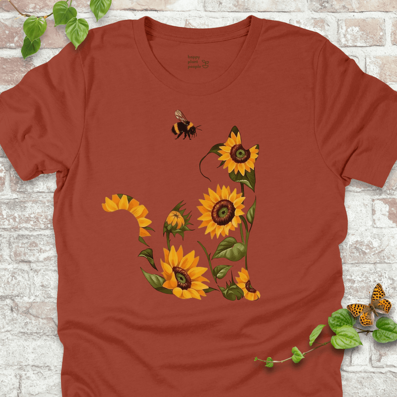 Cute T-shirt in rust with a floral cat design made of sunflowers and a bee. Cozy fall garden-themed shirt for plant lovers and cat fans.