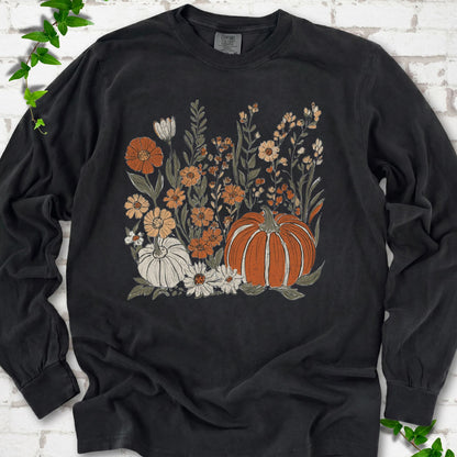 Black Comfort Colors® long sleeve T-shirt flat lay featuring an orange pumpkin surrounded by cream and orange wildflowers.