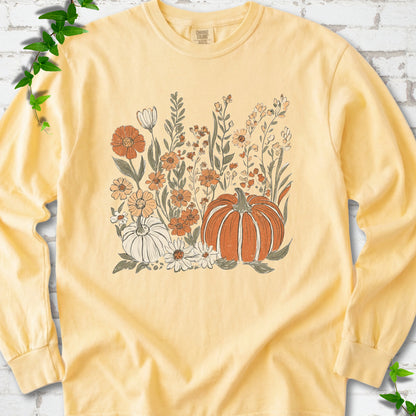 Butter Comfort Colors® long sleeve T-shirt flat lay featuring an orange pumpkin surrounded by cream and orange wildflowers.