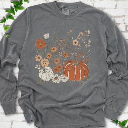 Pepper Comfort Colors® long sleeve T-shirt flat lay featuring an orange pumpkin surrounded by cream and orange wildflowers.