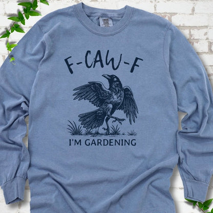 Blue Jean Comfort Colors® long sleeve T-shirt flat lay featuring a black crow with F-CAW-F I'm Gardening text.