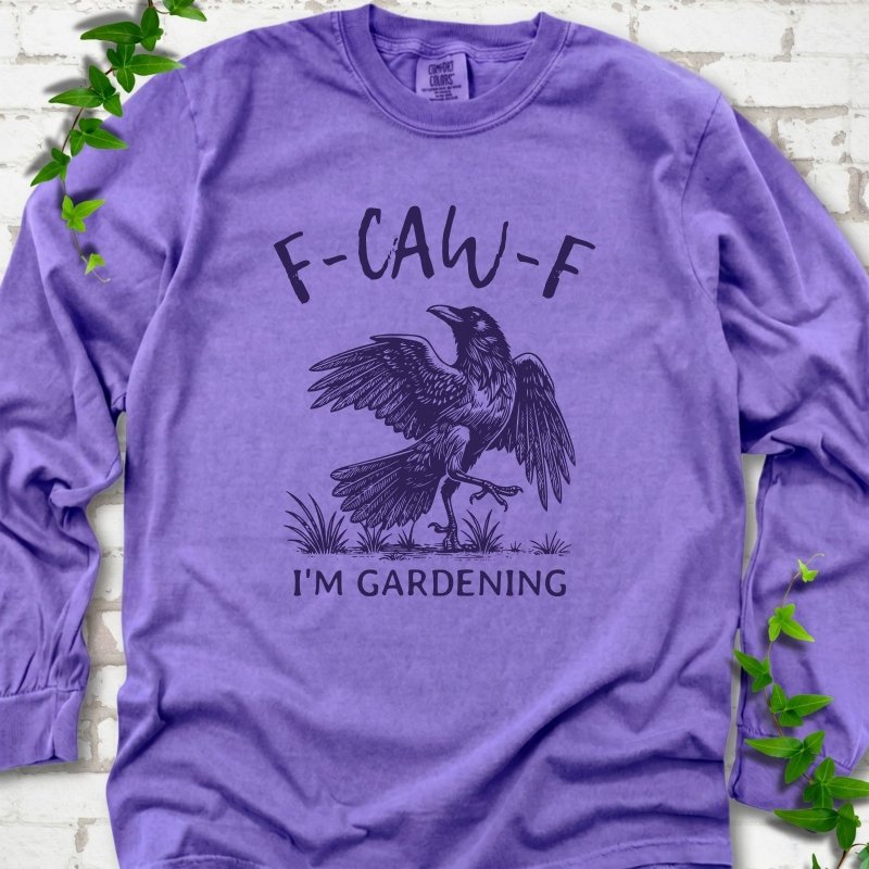 Violet Comfort Colors® long sleeve T-shirt flat lay featuring a black crow with F-CAW-F I'm Gardening text.