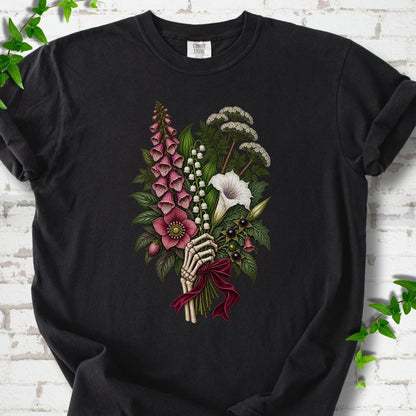 Black Comfort Colors® T-shirt flat lay featuring a poisonous flower bouquet held by skeletal hands.