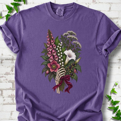 Grape Comfort Colors® T-shirt flat lay featuring a poisonous flower bouquet held by skeletal hands.