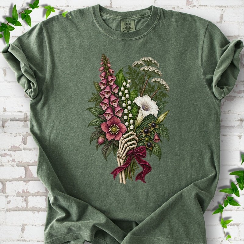 Moss Comfort Colors® T-shirt flat lay featuring a poisonous flower bouquet held by skeletal hands.