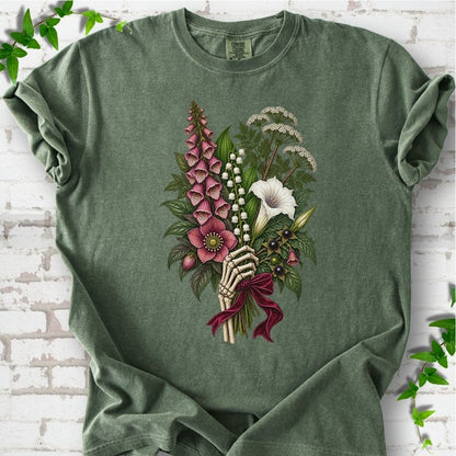Moss Comfort Colors® T-shirt flat lay featuring a poisonous flower bouquet held by skeletal hands.
