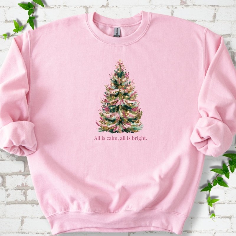 Light Pink sweatshirt laid flat, featuring a decorated evergreen tree with pink ribbon garlands, a pink bow and gold ornaments above the words 'All is calm, all is bright.'