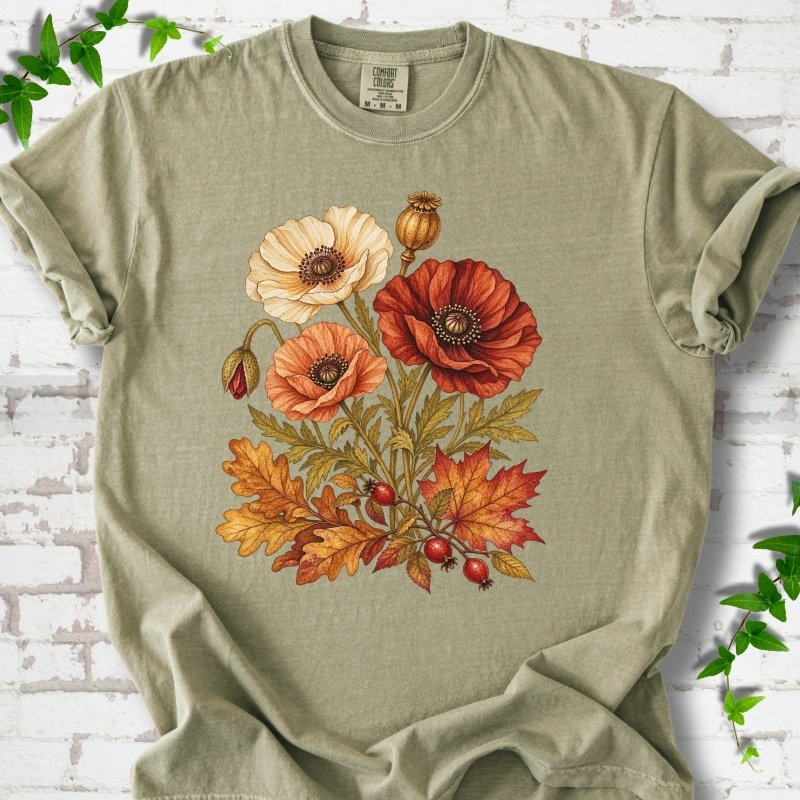 Khaki sage short sleeve t-shirt with a botanical bouquet of cream, peach and deep red poppies with a seed pod, oak and maple leaves and red rose hips, printed on the chest, flat lay on white brick with ivy