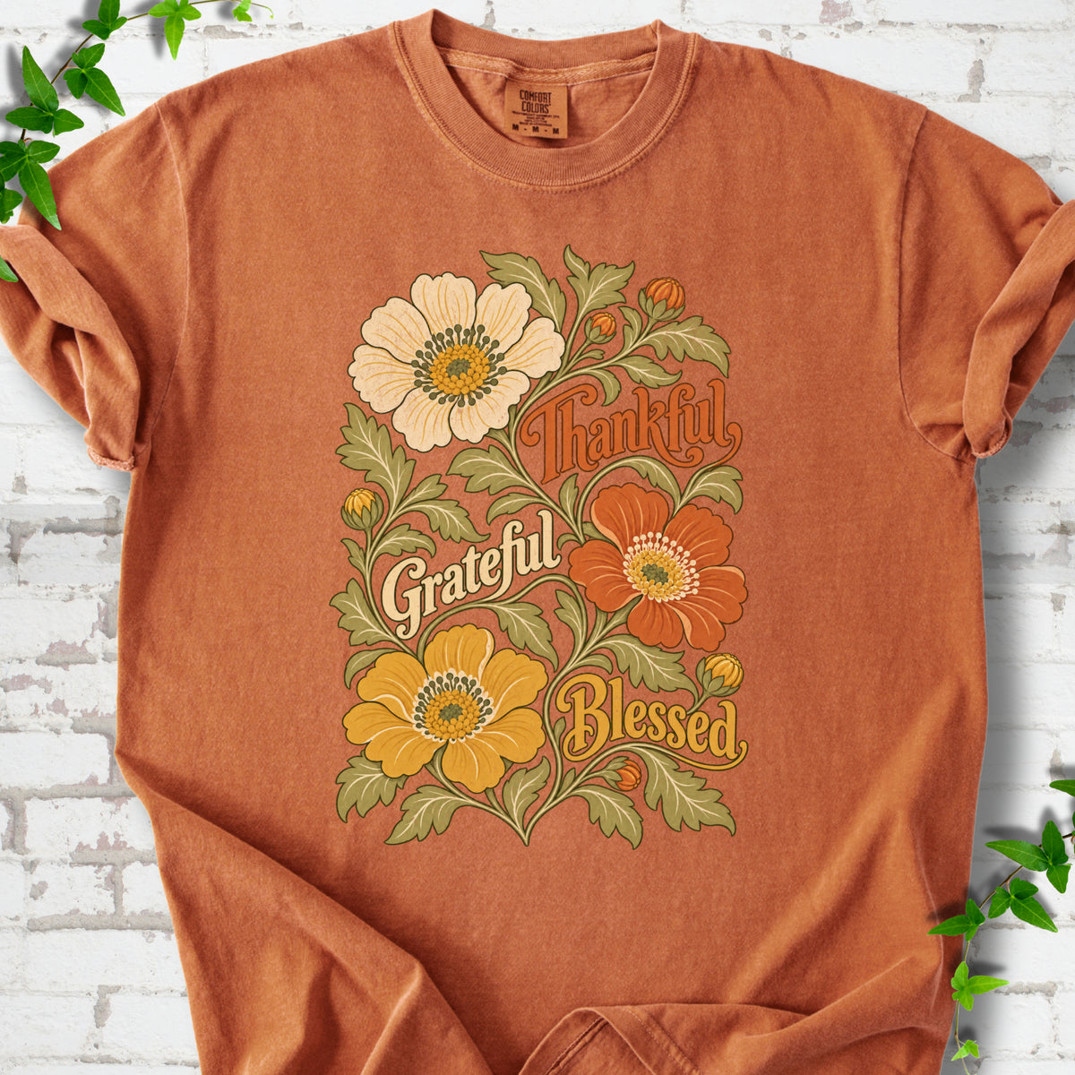 Yam T-shirt flat-lay mockup with orange, cream and yellow flowers framing "Thankful, Grateful, Blessed" lettering.