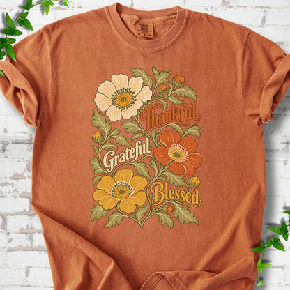 Yam T-shirt flat-lay mockup with orange, cream and yellow flowers framing "Thankful, Grateful, Blessed" lettering.