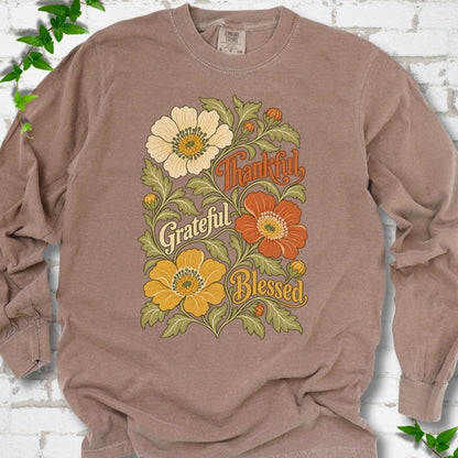 Espresso long sleeve T-shirt flat-lay mockup with orange, cream and yellow flowers framing "Thankful, Grateful, Blessed" lettering.