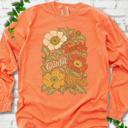 Melon long sleeve T-shirt flat-lay mockup with orange, cream and yellow flowers framing "Thankful, Grateful, Blessed" lettering.