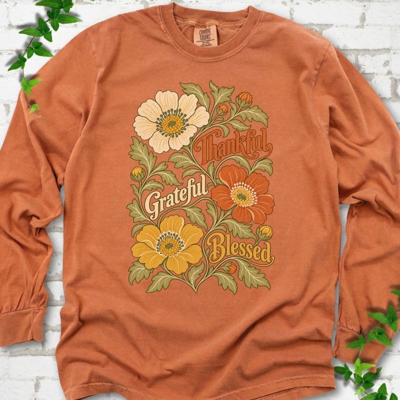 Yam long sleeve T-shirt flat-lay mockup with orange, cream and yellow flowers framing "Thankful, Grateful, Blessed" lettering.