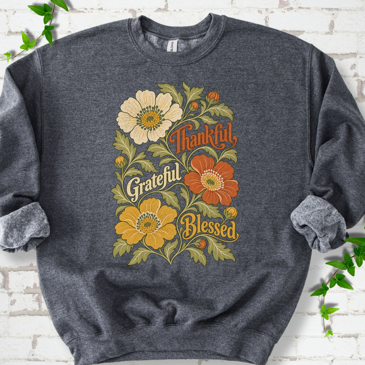 Dark Heather sweatshirt flat-lay mockup with orange, cream and yellow flowers framing "Thankful, Grateful, Blessed" lettering.