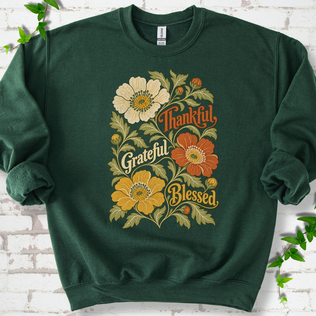 Forest Green sweatshirt flat-lay mockup with orange, cream and yellow flowers framing "Thankful, Grateful, Blessed" lettering.