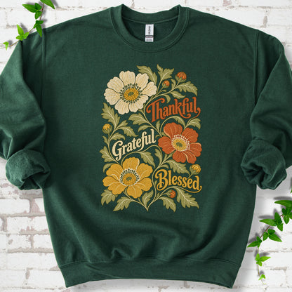 Forest Green sweatshirt flat-lay mockup with orange, cream and yellow flowers framing "Thankful, Grateful, Blessed" lettering.