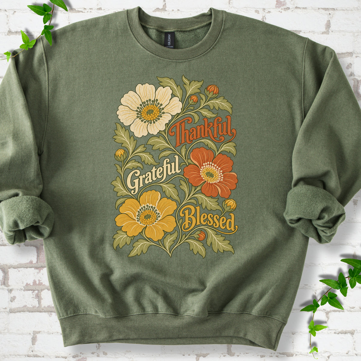 Military Green sweatshirt flat-lay mockup with orange, cream and yellow flowers framing "Thankful, Grateful, Blessed" lettering.