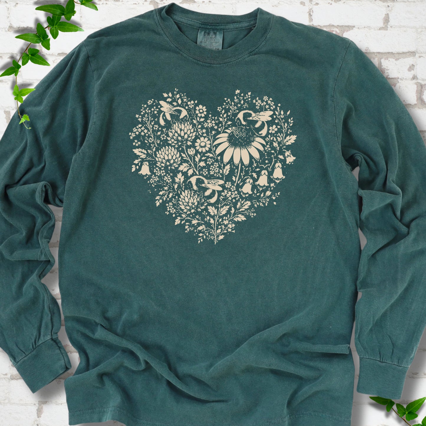 Blue Spruce Comfort Colors® long sleeve T-shirt front mockup featuring three bumblebees among wildflowers in a heart-shaped design.