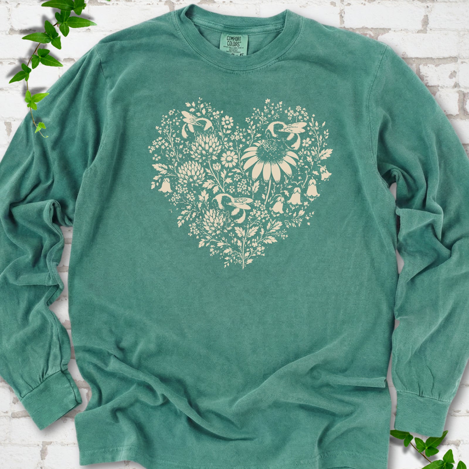 Light Green Comfort Colors® long sleeve T-shirt front mockup featuring three bumblebees among wildflowers in a heart-shaped design.