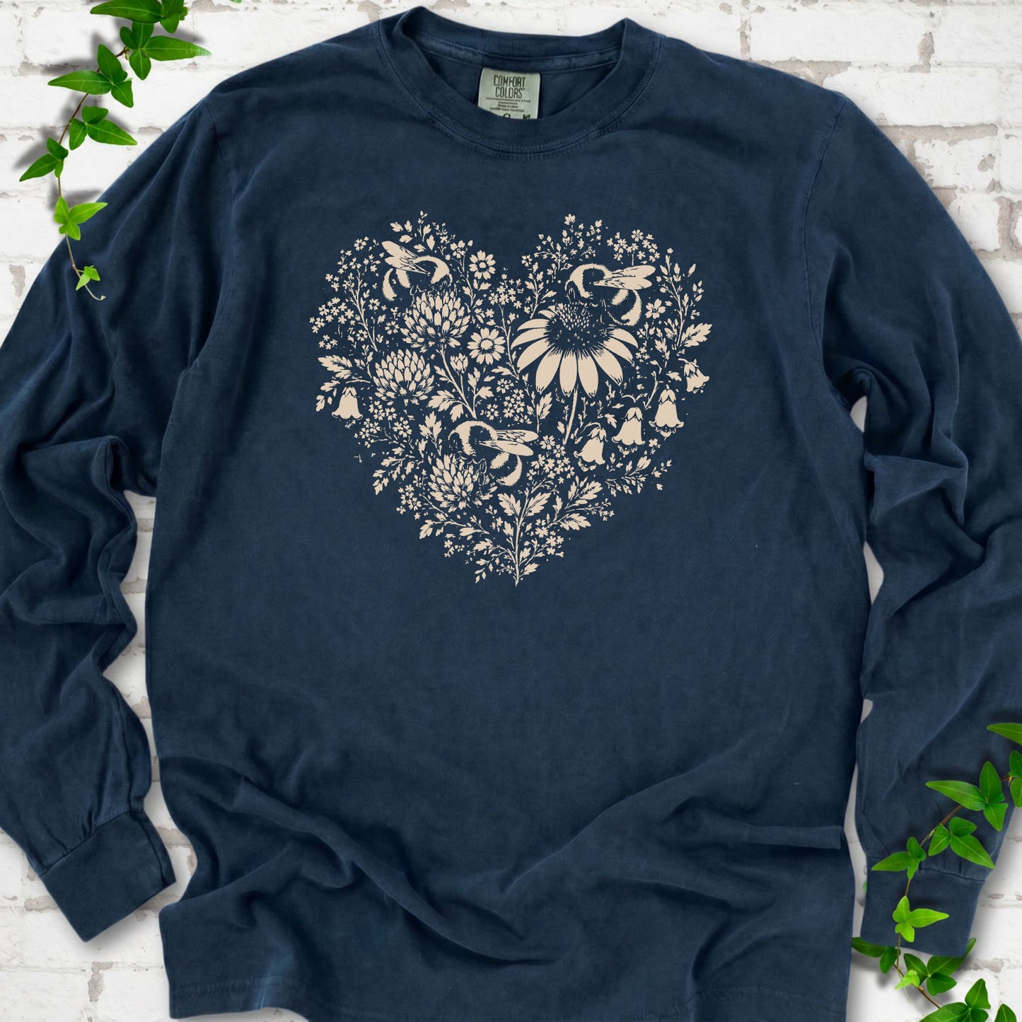 Midnight Comfort Colors® long sleeve T-shirt front mockup featuring three bumblebees among wildflowers in a heart-shaped design.