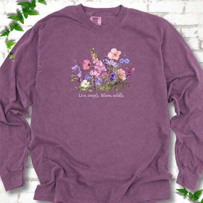 Berry Comfort Colors® long sleeve T-shirt front mockup featuring colorful wildflowers and the words “Live simply. Bloom wildly.”