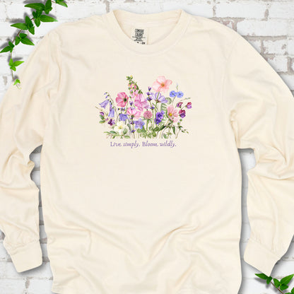 Ivory Comfort Colors® long sleeve T-shirt front mockup featuring colorful wildflowers and the words “Live simply. Bloom wildly.”