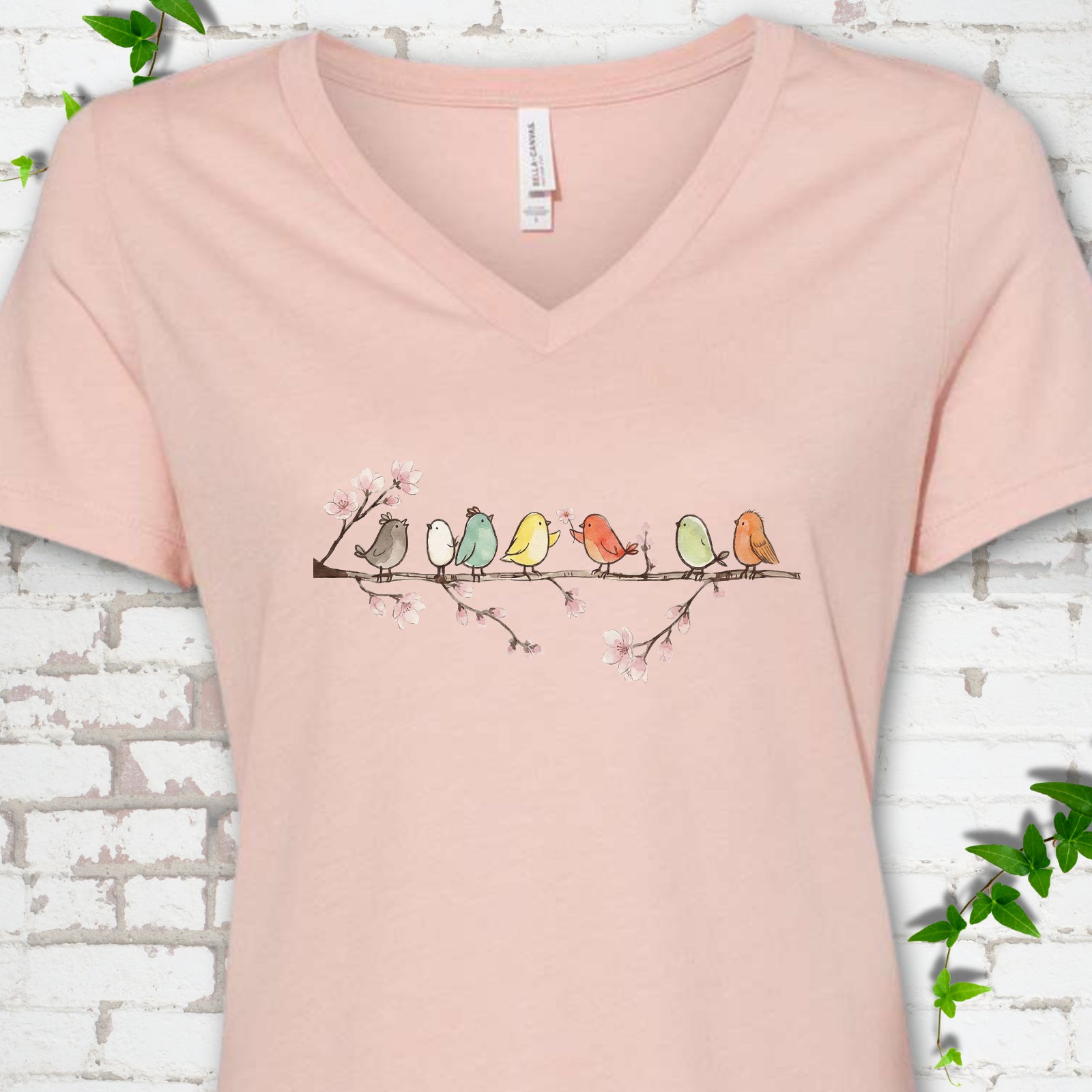 Heather Peach Bella Canvas® V-neck T-shirt front mockup featuring watercolor-style birds on a flowering blossom branch.