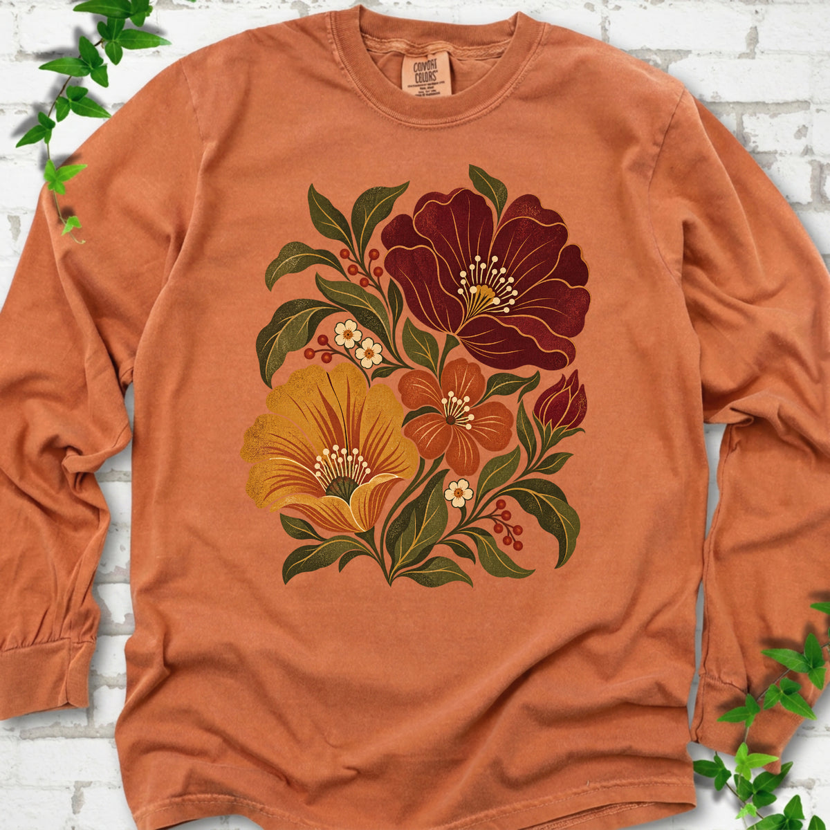 Yam long sleeve T-shirt front-view mockup with a large burgundy, ochre and rust retro floral graphic.