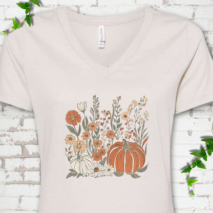 Heather Dust Bella Canvas® V-neck T-shirt flat lay featuring an orange pumpkin surrounded by cream and orange wildflowers.