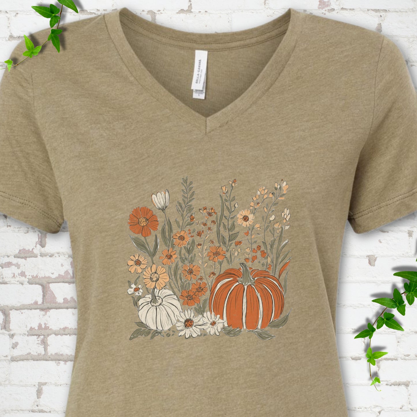 Heather Olive Bella Canvas® V-neck T-shirt flat lay featuring an orange pumpkin surrounded by cream and orange wildflowers.