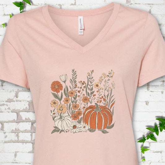 Heather Peach Bella Canvas® V-neck T-shirt flat lay featuring an orange pumpkin surrounded by cream and orange wildflowers.