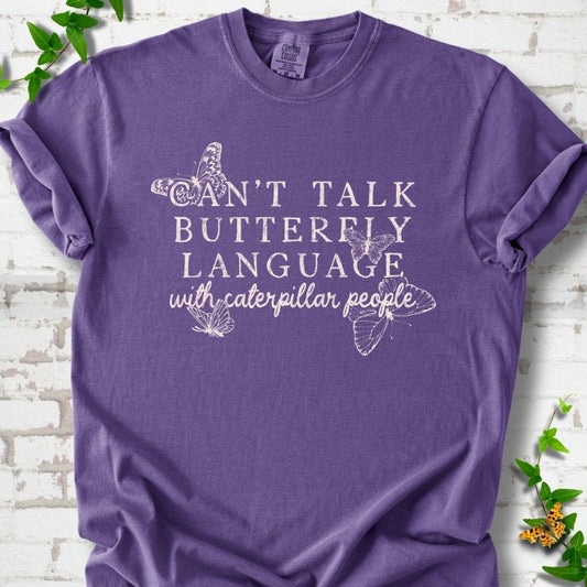 Grape Comfort Colors® T-shirt featuring a cream Can't Talk Butterfly Language with Caterpillar People graphic with butterflies