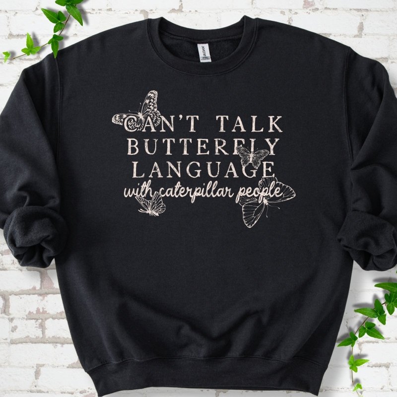 Black classic sweatshirt featuring a cream Can't Talk Butterfly Language with Caterpillar People graphic with butterflies