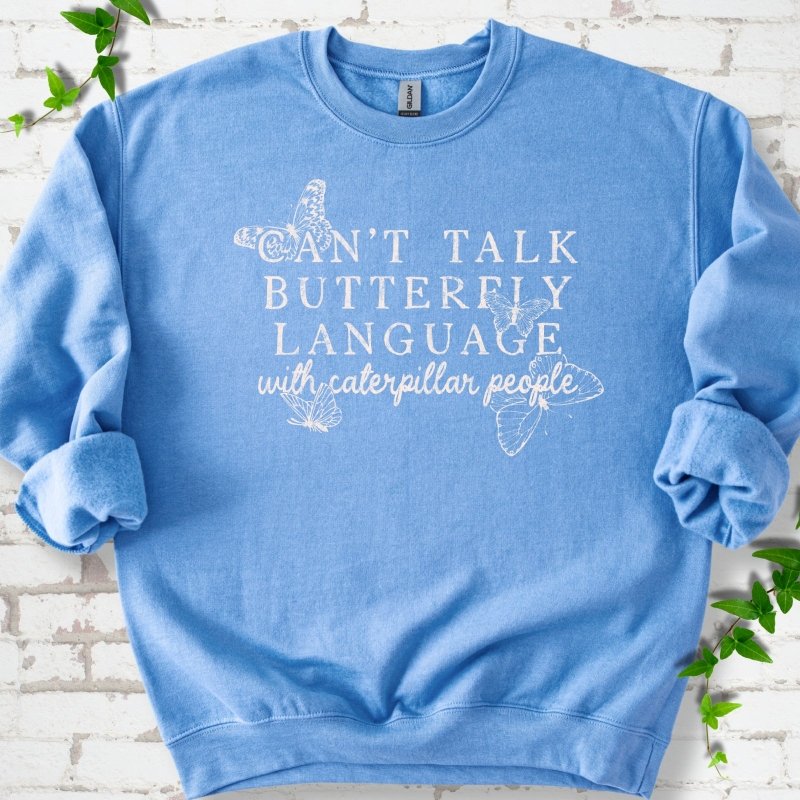 Carolina Blue classic sweatshirt featuring a cream Can't Talk Butterfly Language with Caterpillar People graphic with butterflies
