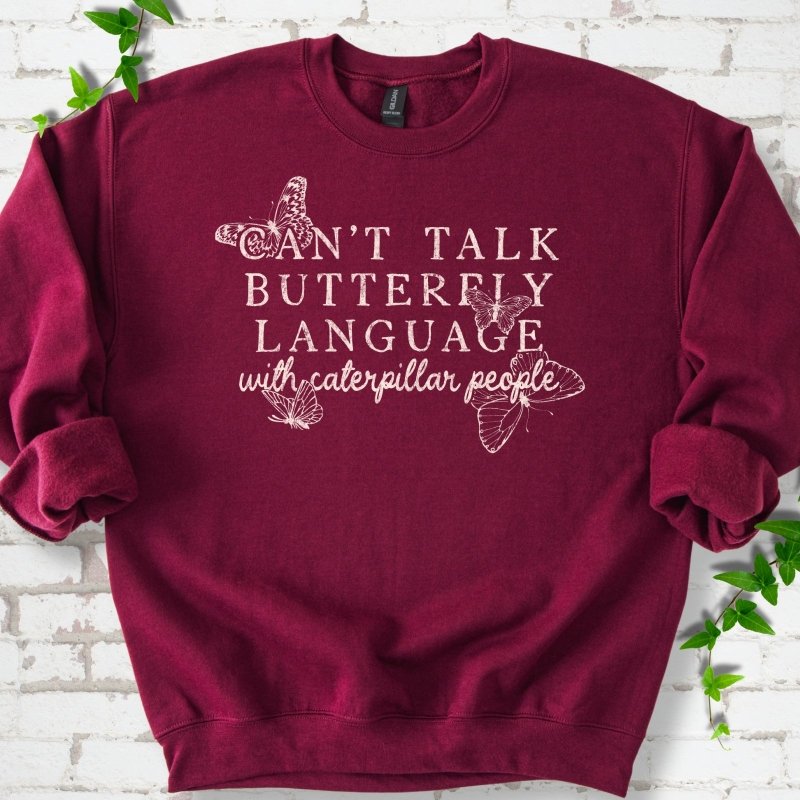 Maroon classic sweatshirt featuring a cream Can't Talk Butterfly Language with Caterpillar People graphic with butterflies