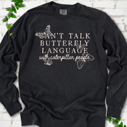Black Comfort Colors® long sleeve T-shirt featuring a cream Can't Talk Butterfly Language with Caterpillar People graphic with butterflies