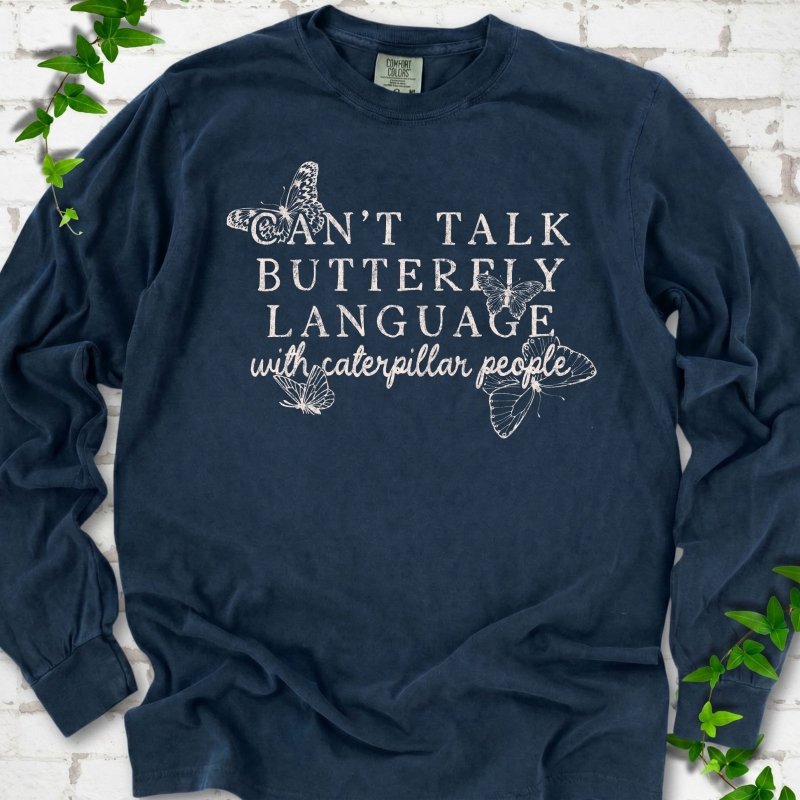 Midnight Comfort Colors® long sleeve T-shirt featuring a cream Can't Talk Butterfly Language with Caterpillar People graphic with butterflies
