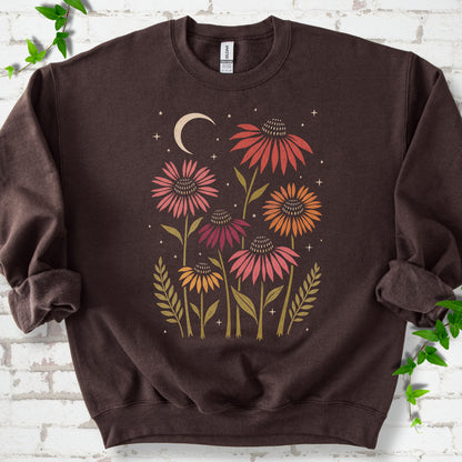 Dark Chocolate classic sweatshirt laid flat, showing warm-toned coneflowers with green leaves, a cream crescent moon and small stars.