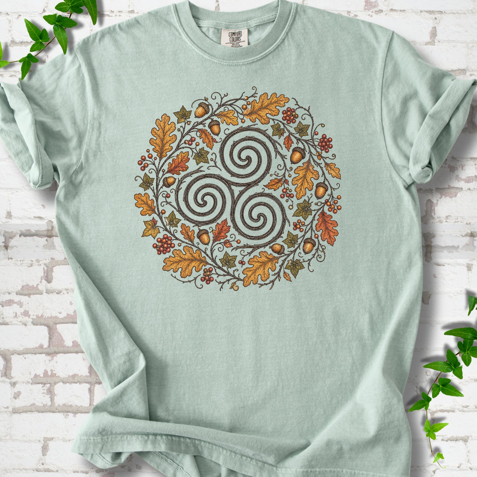 Bay Comfort Colors® T-shirt flat lay with a Celtic-inspired triskele and autumn oak wreath design.