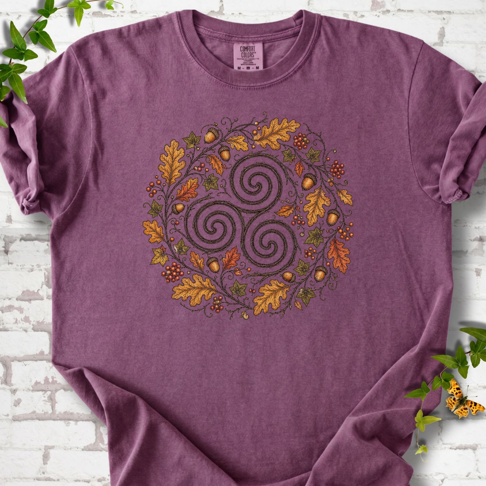 Berry Comfort Colors® T-shirt flat lay with a Celtic-inspired triskele and autumn oak wreath design.