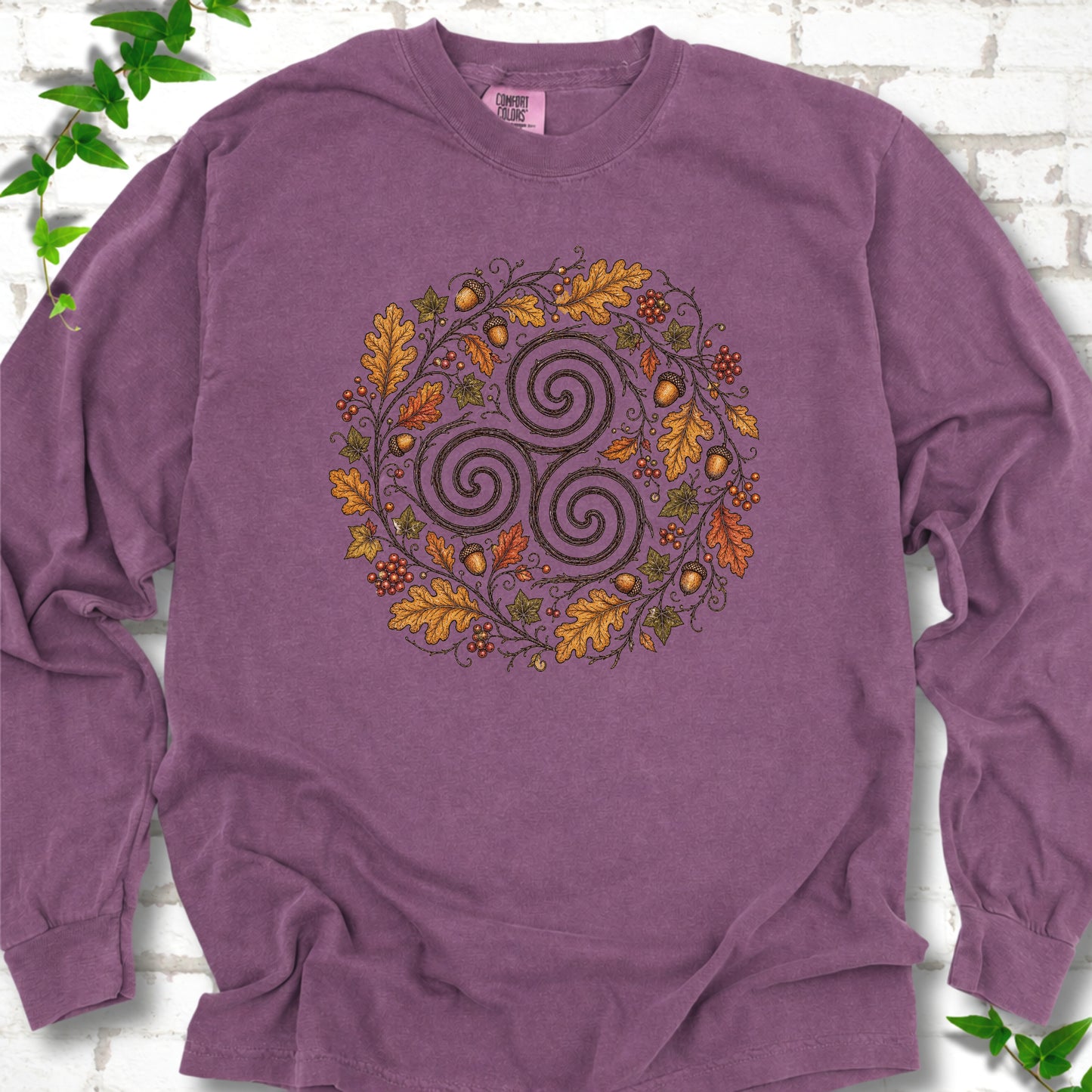 Berry Comfort Colors® long sleeve T-shirt flat lay with a Celtic-inspired triskele and autumn oak wreath design.