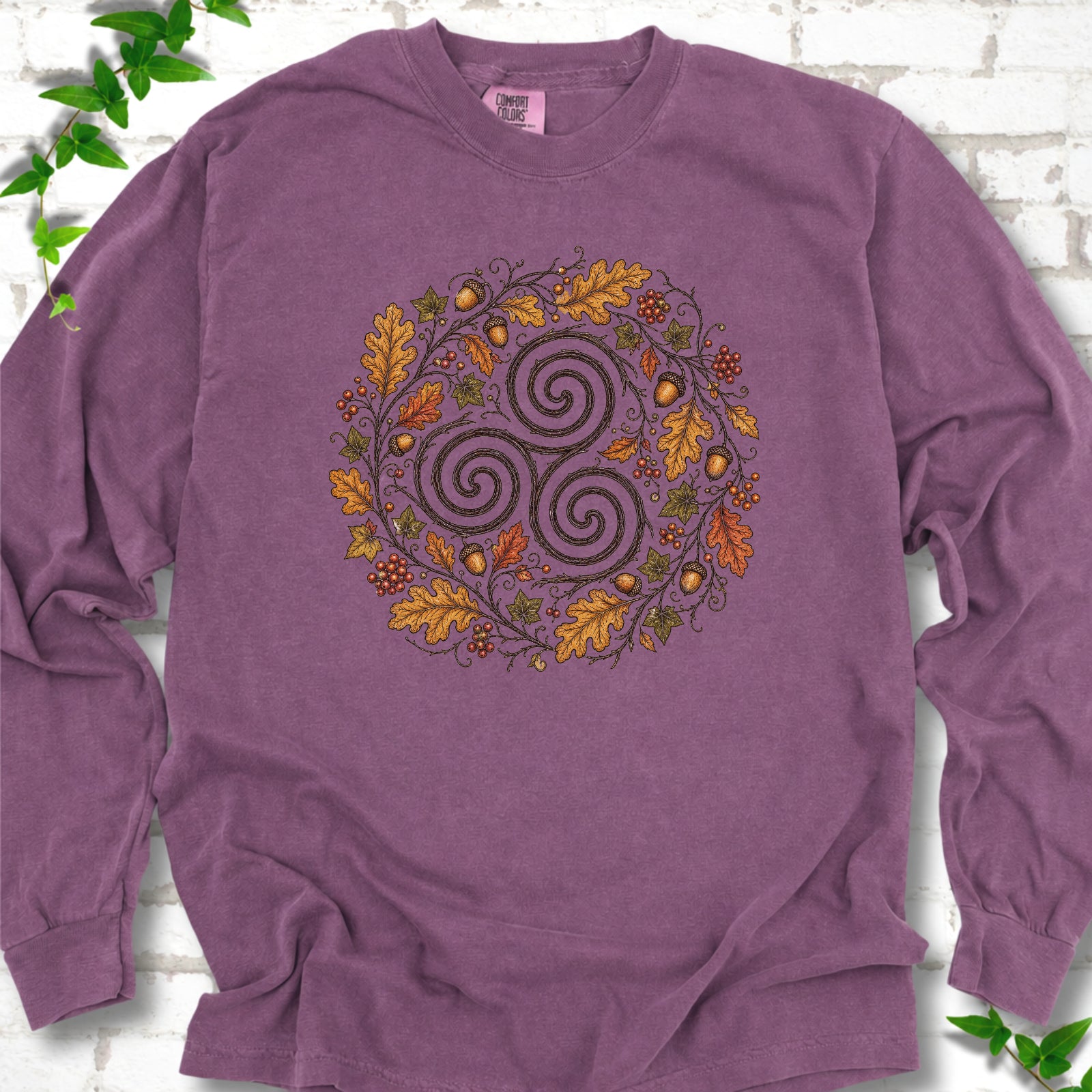 Berry Comfort Colors® long sleeve T-shirt flat lay with a Celtic-inspired triskele and autumn oak wreath design.